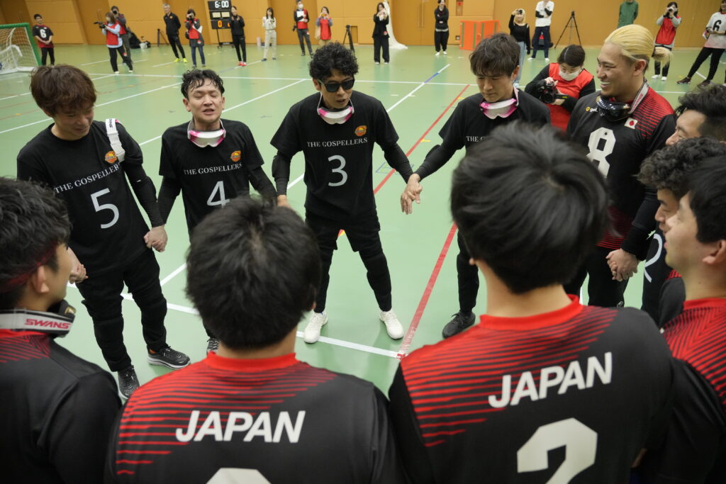 女子強化指定選手との試合前に円陣を組むゴスペラーズと男子強化指定選手たち